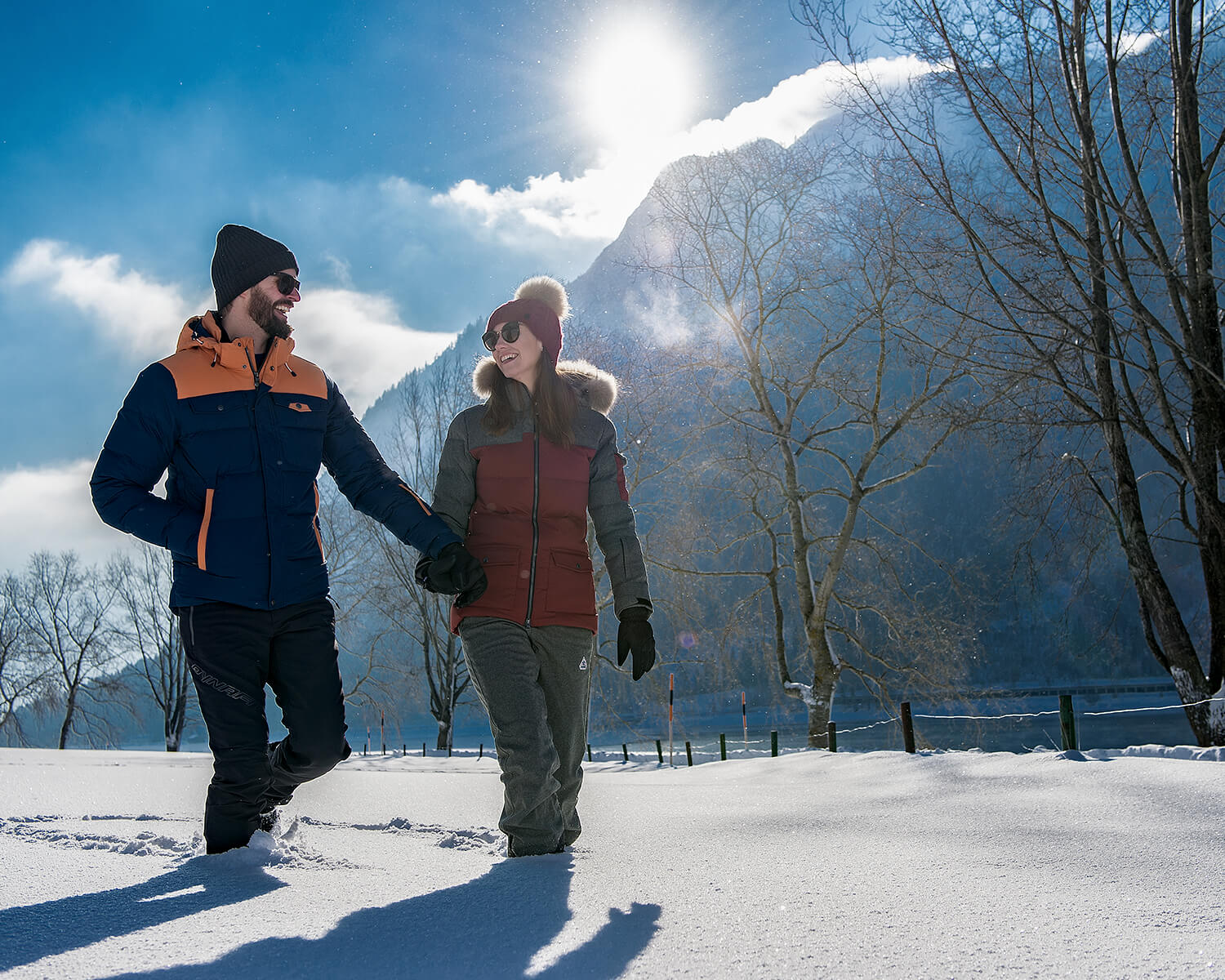 Couple enjoys sunny winter day walking in the snow